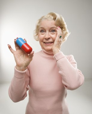 Woman holding pill. clipart