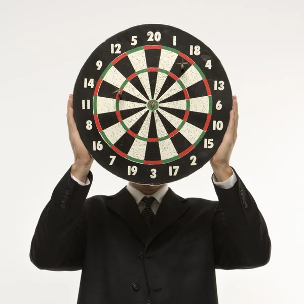 Dartboard in front of face. — Stock Photo, Image