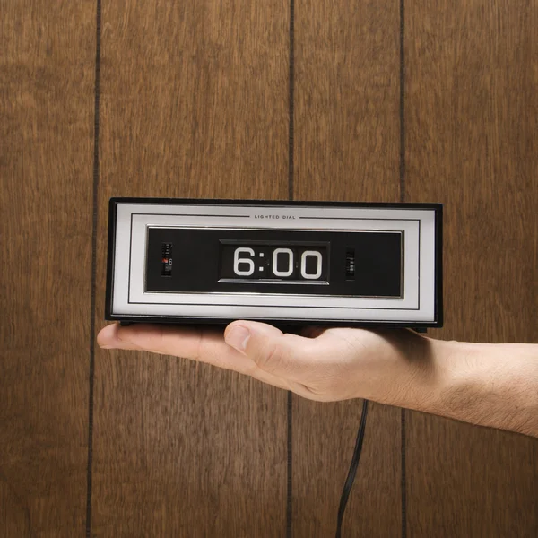 Mão segurando relógio de alarme . — Fotografia de Stock