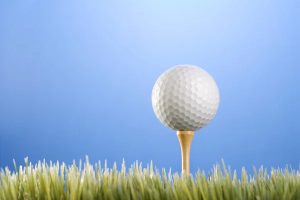 Golfball na odpališti v trávě. — Stock fotografie