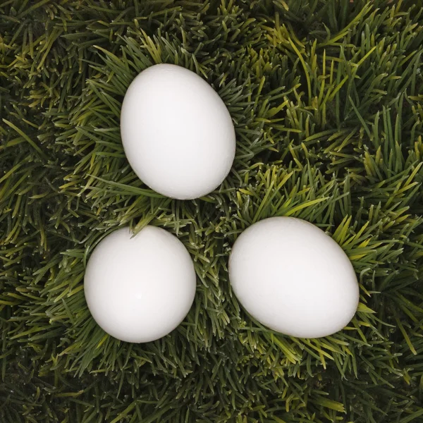 Tres huevos blancos en la hierba . —  Fotos de Stock