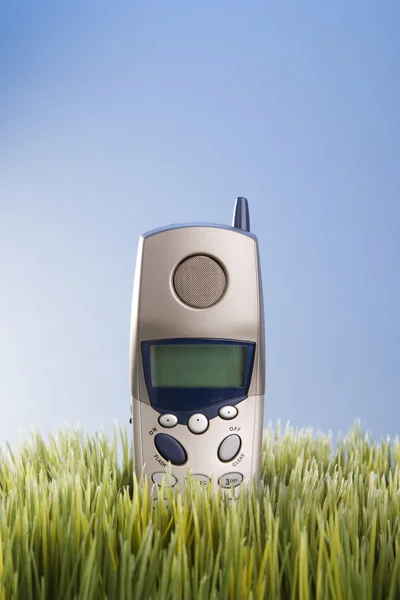 Sladdlös telefon i gräs. — Stockfoto