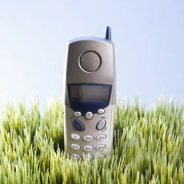 Sladdlös telefon i gräs. — Stockfoto