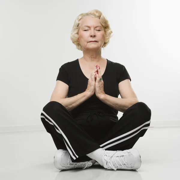 Starší žena medituje. — Stock fotografie