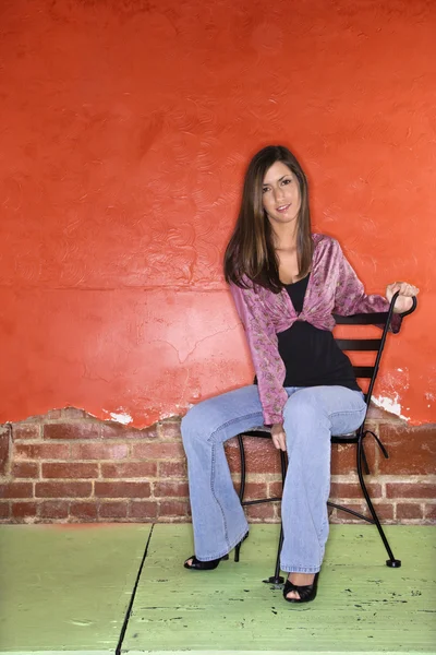 Junge Frau sitzt auf Stuhl — Stockfoto