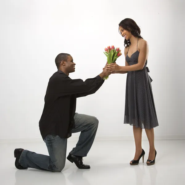 Man giving woman flowers. — Stock Photo, Image