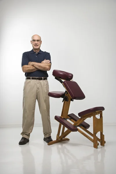 Masajista terapeuta y silla . — Foto de Stock