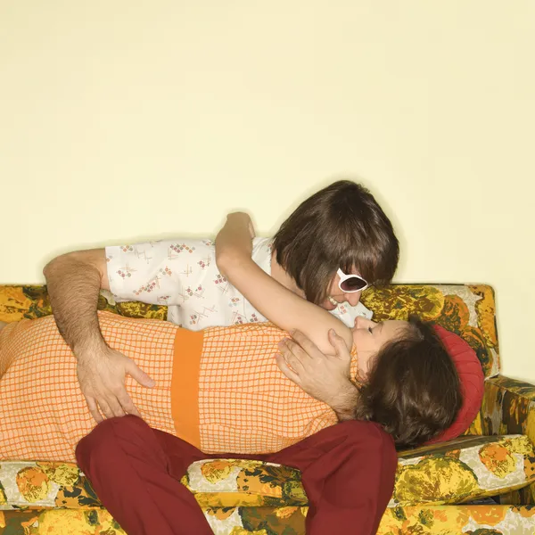 Par kyssas på soffa. — Stockfoto