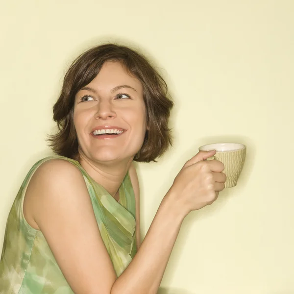 Frau lächelt mit Tasse. — Stockfoto