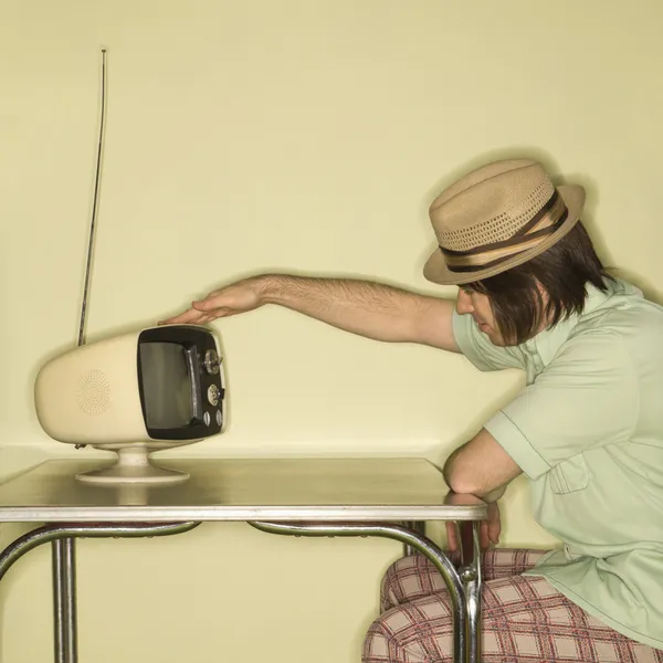 Man tapping retro TV. — Stock Photo, Image