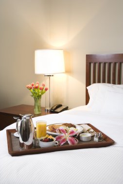 Breakfast tray on white bed. clipart