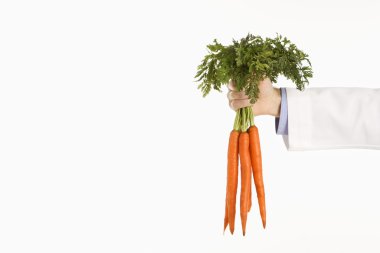 Doctor holding carrots. clipart