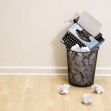 Typewriter in trash can. clipart