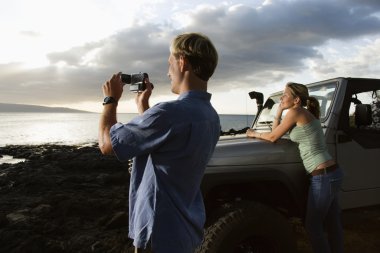 Tourist Couple Enjoying a Beach Sunset clipart