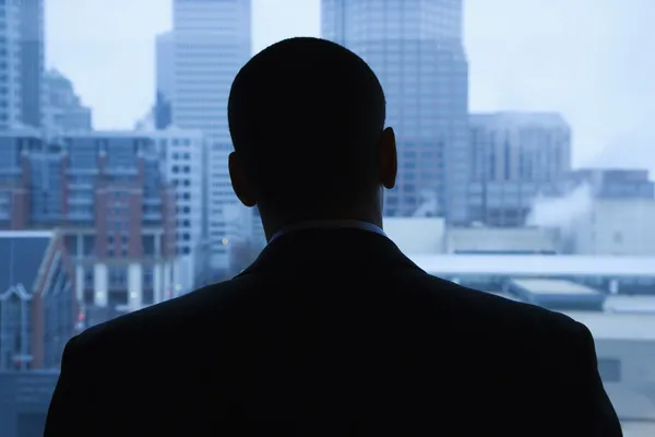 Επιχειρηματίας κοιτάζοντας έξω από το παράθυρο — Φωτογραφία Αρχείου