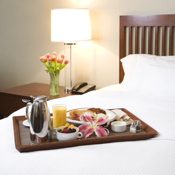 Breakfast tray on white bed. — Stock Photo, Image