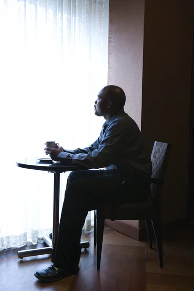Бизнесмен, сидящий у окна кафе — стоковое фото