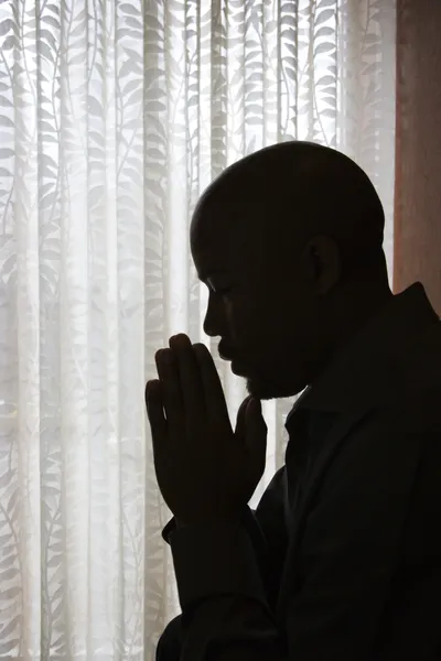 Человек с руками в молитве — стоковое фото