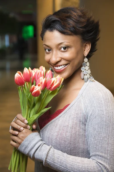 Porträt einer lächelnden Frau mit Tulpen — Stockfoto