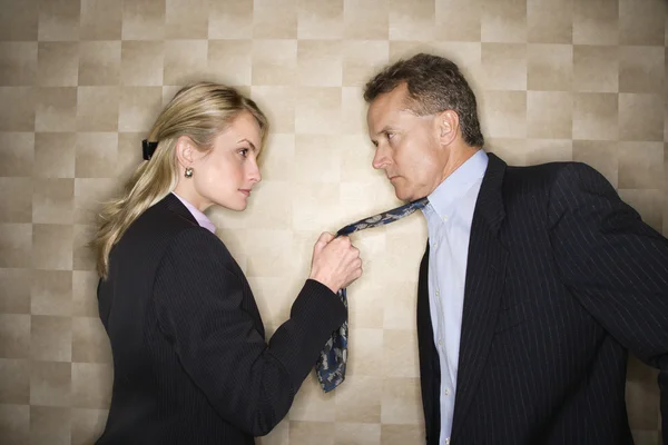Arrabbiata donna d'affari tirando cravatta dell'uomo — Foto Stock
