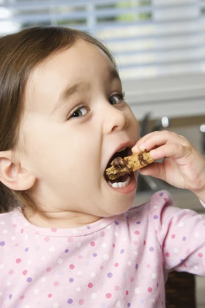 Girl eating cookie. — Stock Photo, Image