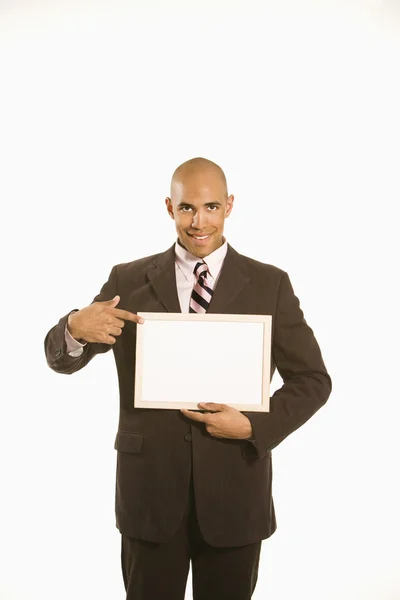 Empresario sosteniendo cartel en blanco. — Foto de Stock