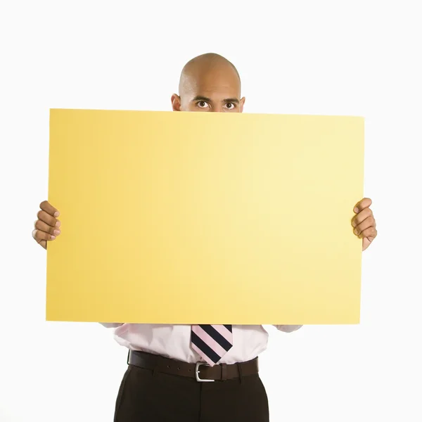 Empresario sosteniendo cartel en blanco. — Foto de Stock