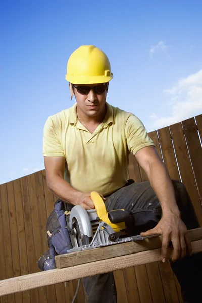 Robotnik budowlany, piłowanie drewna — Zdjęcie stockowe