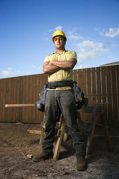 Erkek inşaat işçisi ile katlanmış silah anlamına gelir. — Stok fotoğraf