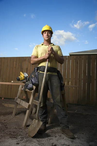 シャベルで立っている建設労働者 — ストック写真