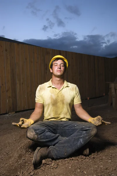 Meditierender Bauarbeiter — Stockfoto