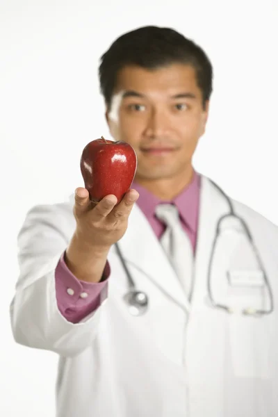 Доктор держит яблоко . — стоковое фото