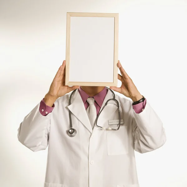 Doctor sosteniendo signo en blanco . — Foto de Stock