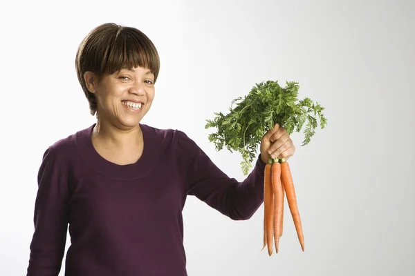 Woman holding carrots. — Stock Photo, Image