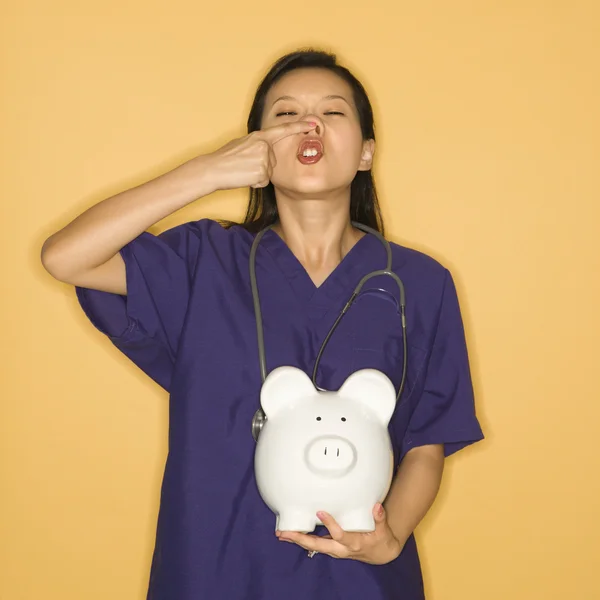 Doctor and piggy bank. — Stock Photo, Image