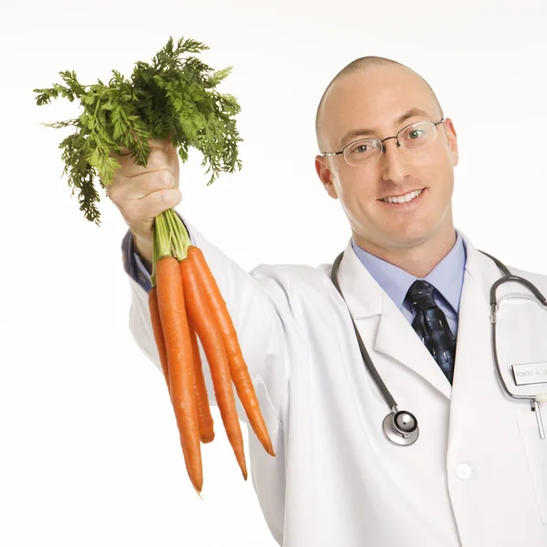 Médico segurando cenouras . — Fotografia de Stock