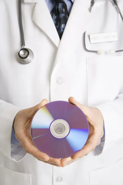 Doctor holding compact disc. — Stock Photo, Image