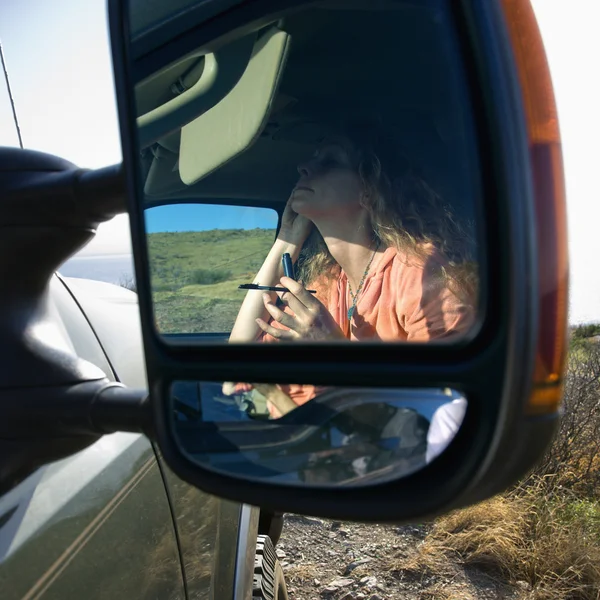 Frau schminkt sich im Auto. — Stockfoto