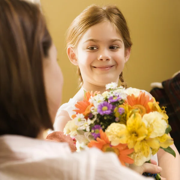 Girl giving mom flowers. — Stock Photo, Image