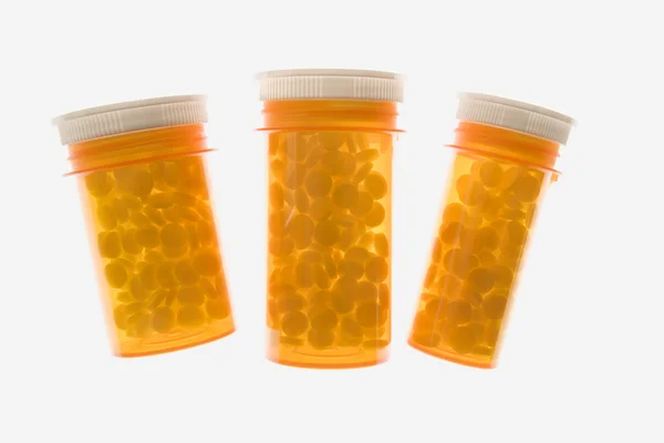 Três garrafas de medicina plástica amarela. Isolados — Fotografia de Stock