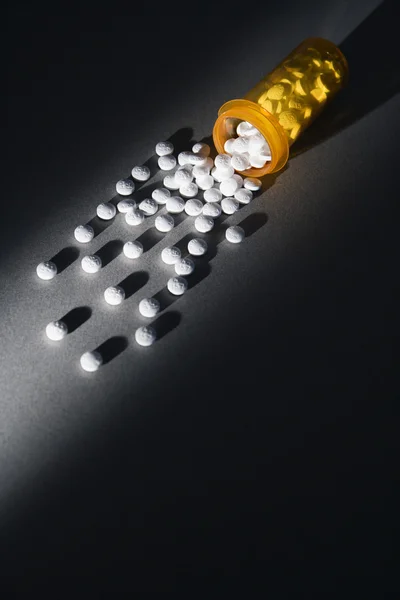 Comprimidos de derramamento de garrafa de medicina amarela — Fotografia de Stock