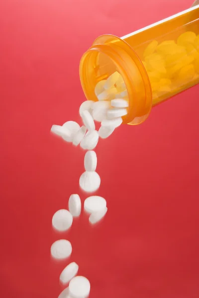 Pillen, die aus einem Behälter gegossen werden. isoliert — Stockfoto