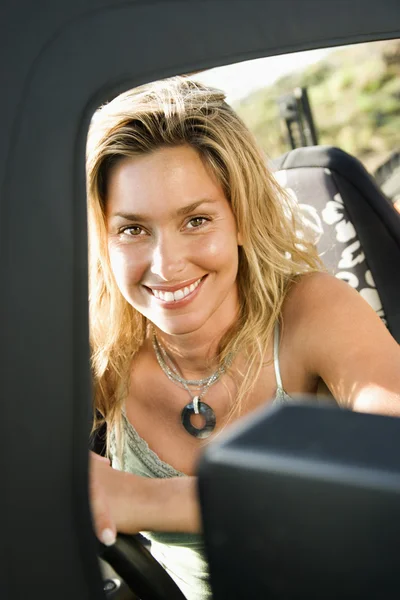 Mujer sonriente sentada en el coche — Foto de Stock