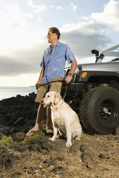 Чоловіки і собаки позашляховика на пляжі — стокове фото