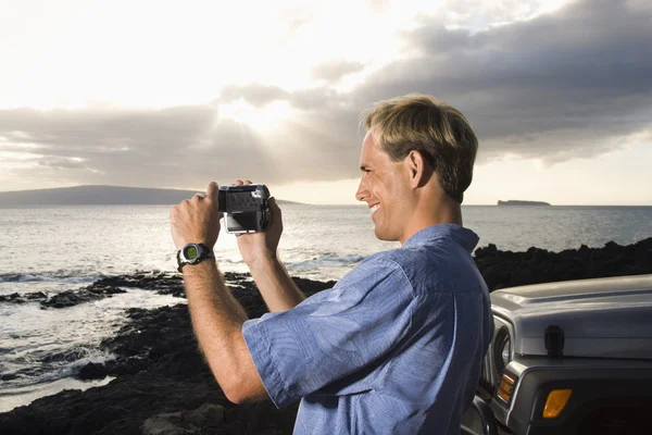 Człowiek za pomocą kamery wideo na plaży — Zdjęcie stockowe