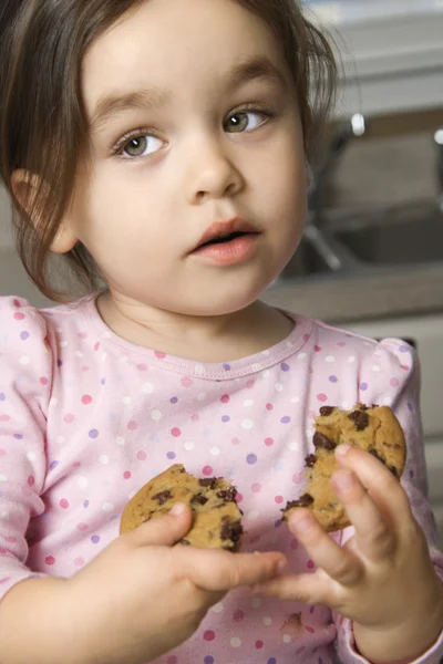 Menina comer biscoito . Fotos De Bancos De Imagens Sem Royalties