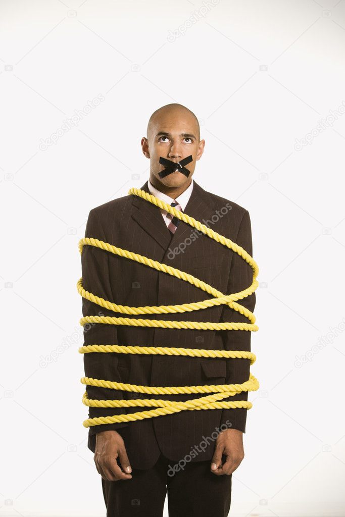 Businessman tied in rope.