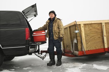 Man going ice fishing. clipart