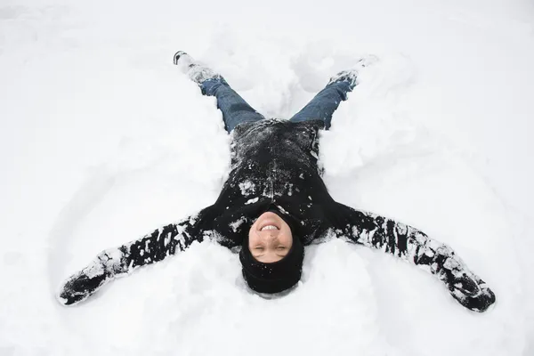 Kvinna som gör snö ängel. — Stockfoto