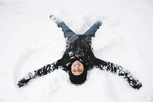Mulher fazendo anjo da neve . Imagens De Bancos De Imagens Sem Royalties